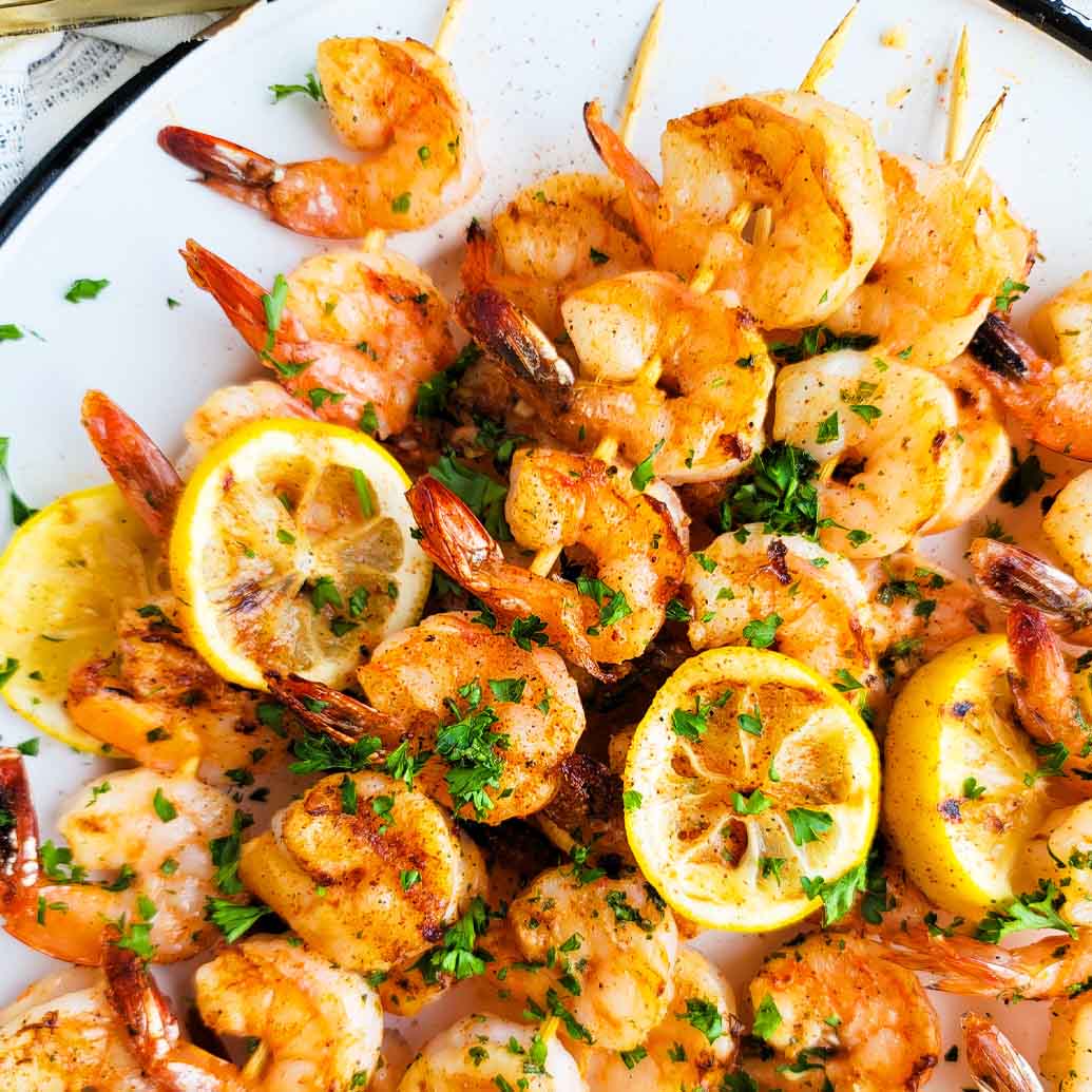shrimp on bamboo skewers topped with cliantro and lemons